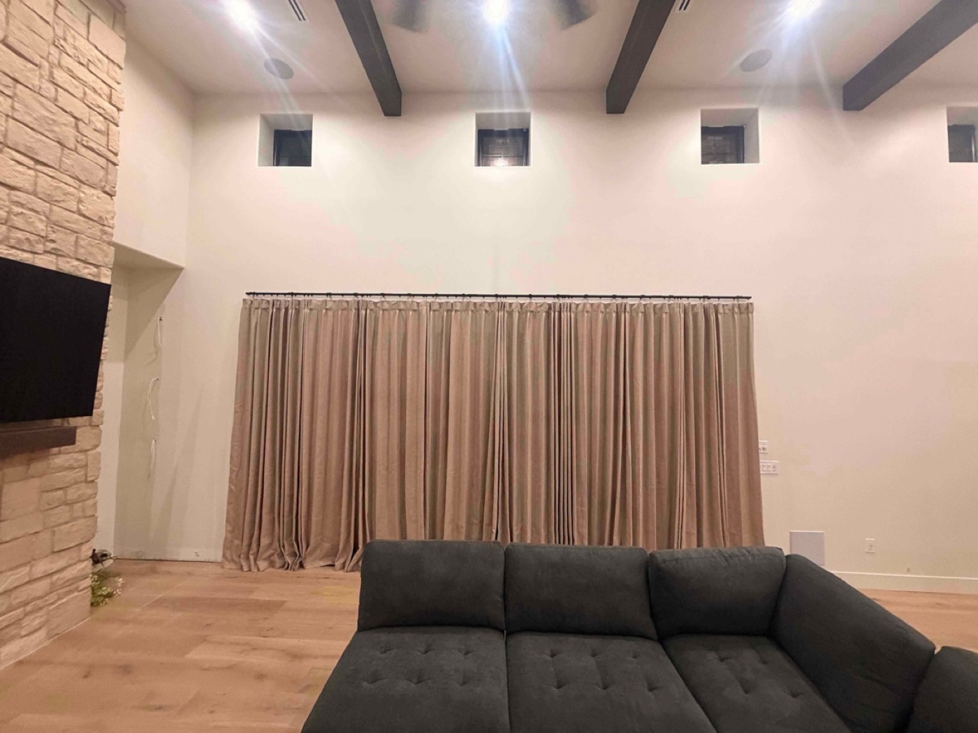Floor-to-ceiling curtains hung on a long rod across a wall of windows